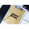 Montblanc pen on wooden clipboard with keyboard and notebook