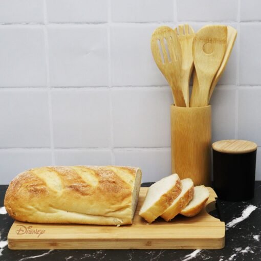 Sliced bread on wooden board with kitchen utensils