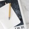 Dior pencil on notebook with artistic cover